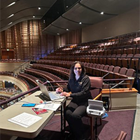 Lois Boyle prepares to provide open captioning at Sandler Center for the Performing Arts